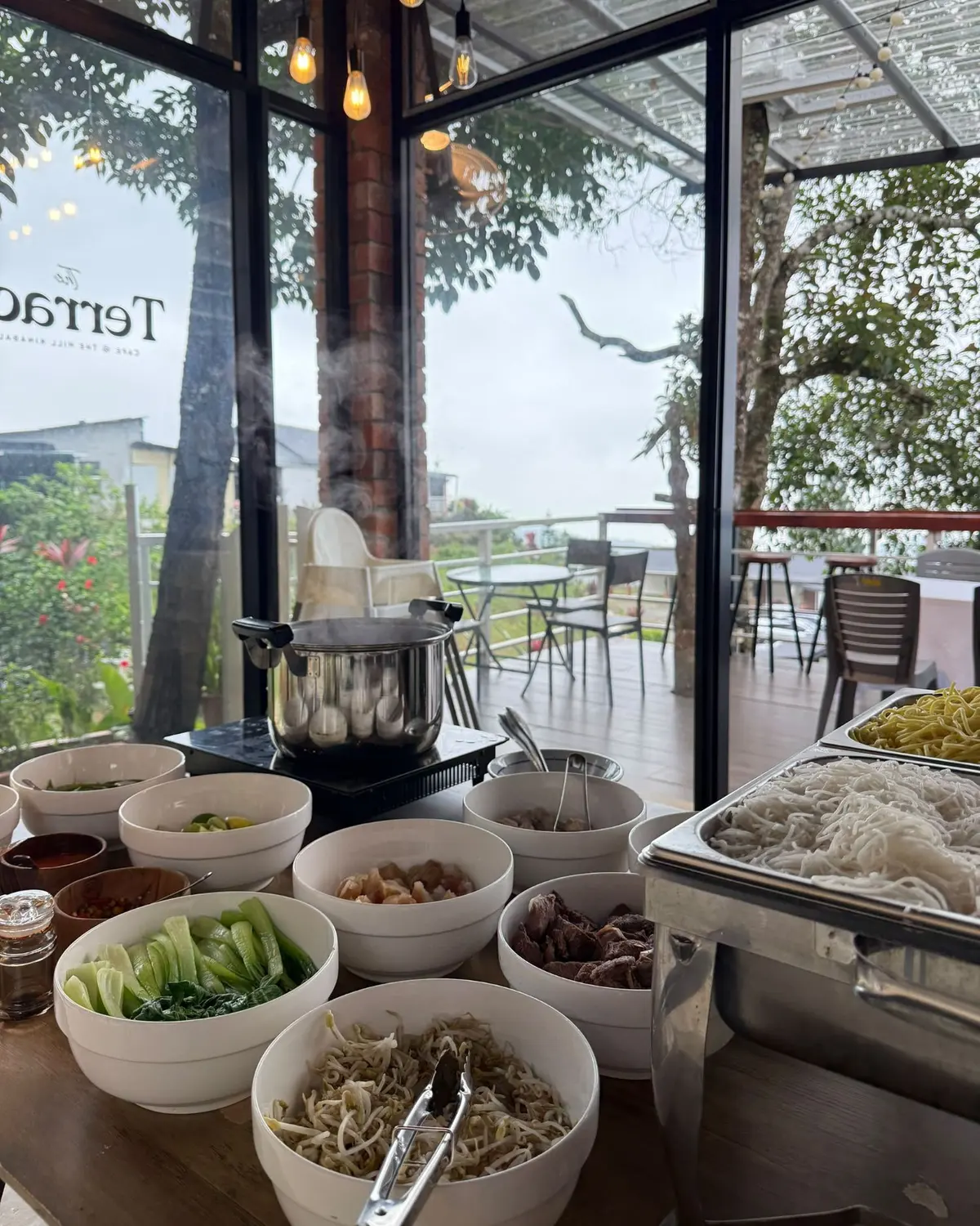 A steaming noodle bar laid out at The Terrace on a misty morning